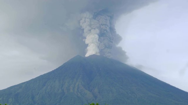 Smoke and ash plume rising from Agung volcano summit during eruption. Bali, Indonesia