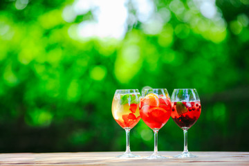 Summer cocktail. Fruit cocktail on green background. Citrus fruits, berries, strawberries, blueberries, mint, ice.