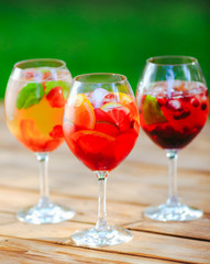 Summer cocktail. Fruit cocktail on green background. Citrus fruits, berries, strawberries, blueberries, mint, ice.