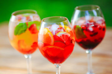 Summer cocktail. Fruit cocktail on green background. Citrus fruits, berries, strawberries, blueberries, mint, ice.