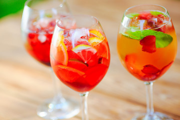 Summer cocktail. Fruit cocktail on green background. Citrus fruits, berries, strawberries, blueberries, mint, ice.