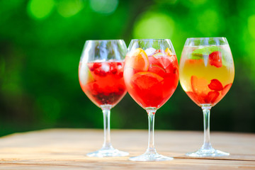 Summer cocktail. Fruit cocktail on green background. Citrus fruits, berries, strawberries, blueberries, mint, ice.