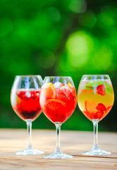 Summer cocktail. Fruit cocktail on green background. Citrus fruits, berries, strawberries, blueberries, mint, ice.