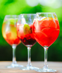 Summer cocktail. Fruit cocktail on green background. Citrus fruits, berries, strawberries, blueberries, mint, ice.