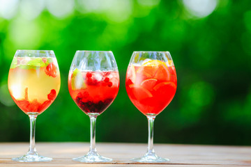 Summer cocktail. Fruit cocktail on green background. Citrus fruits, berries, strawberries, blueberries, mint, ice.