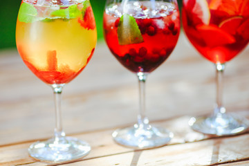 Summer cocktail. Fruit cocktail on green background. Citrus fruits, berries, strawberries, blueberries, mint, ice.