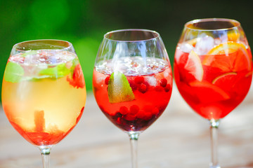 Summer cocktail. Fruit cocktail on green background. Citrus fruits, berries, strawberries, blueberries, mint, ice.