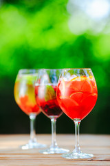 Summer cocktail. Fruit cocktail on green background. Citrus fruits, berries, strawberries, blueberries, mint, ice.