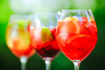 Summer cocktail. Fruit cocktail on green background. Citrus fruits, berries, strawberries, blueberries, mint, ice.