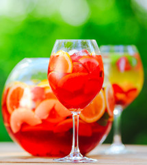 Summer cocktail. Fruit cocktail on green background. Citrus fruits, berries, strawberries, blueberries, mint, ice.