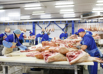 Cutting meat in slaughterhouse .
