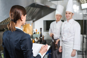 Restaurant manager briefing to his kitchen staff in the commercial kitchen