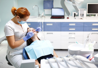 Obraz premium female dentist checking patient girl teeth