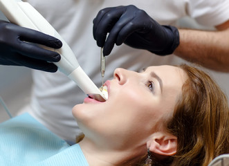 The dentist scans the patient's teeth with a 3d scanner.