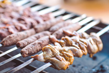 Barbecue from different types of meat in the restaurant on the background of the guests.
