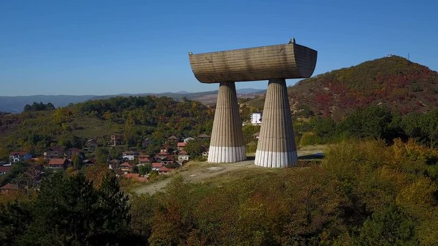 Aerial view of monument structure built on a hill overlooking Mitrovica city in Kosovo