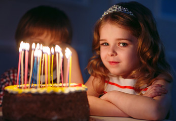 Children's birthday. Children near a birthday cake with candles.