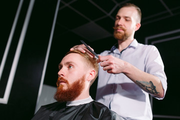Confident man visiting hairstylist in barber shop.
