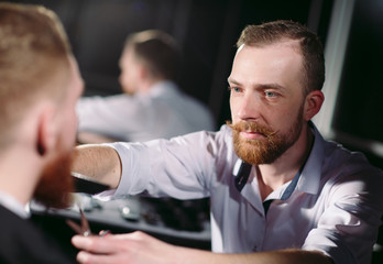 Fototapeta premium Confident man visiting hairstylist in barber shop.