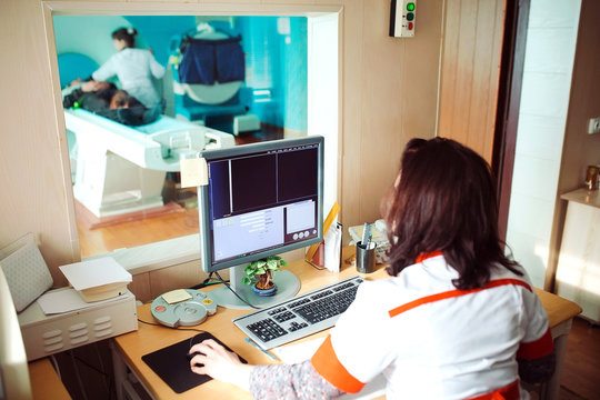 MRI machine and screens with doctor and nurse
