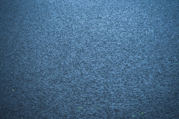 The surface of the water under the raindrops.