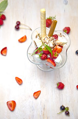 ice cream in glass with berries and cinnamon on wooden background 