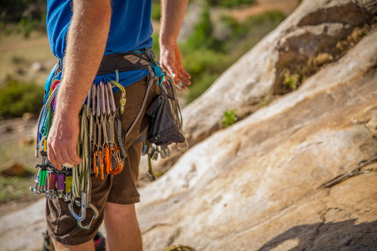 A rock climber with his harness, carabiners and climbing equipment