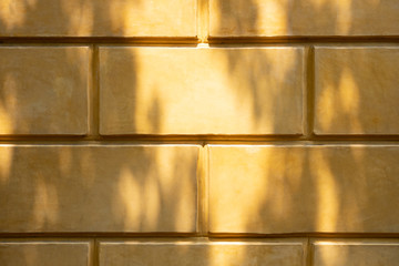 Yellow brick wall in the Roman era for background with shadow