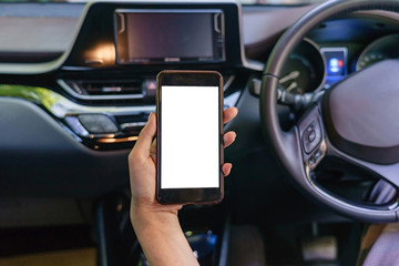 Front view of modern smartphone with blank screen with copy space for your text or design, close-up of female driver hands using mobile phone in a car