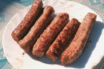 Sausages on a plate from the grill. Close-up.