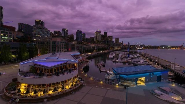 UHD 4k time lapse movie of beautiful sunset over downtown cityscape along waterfront in Seattle Washington into dusk blue hour evening and night ultra high definition