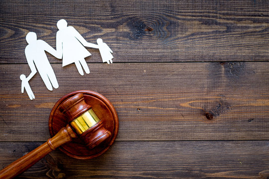 Family law, family right concept. Child-custody concept. Family with children cutout near court gavel on dark wooden background top view copy space