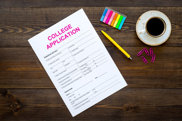 Apply college. Empty college application form near coffee cup and stationery on dark wooden background top view copy space