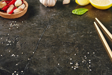 Dark Stone Asian Background with Lemon, Garlic, Hot Red Peppers