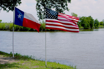 American and Texas Flags Waving by River