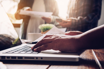 Team  businessmans job . working with laptop in open space office. Meeting report in progress. sun glare effect