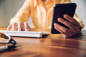 Businesses work through smartphones and laptop in the workplace to communicate and Meeting report in progress collaborate with business teams.