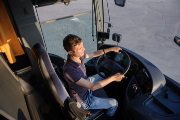 Young  man at the wheel is looking away from the bus