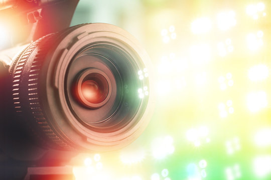 lens of TV camera in stadium with light background during sports match