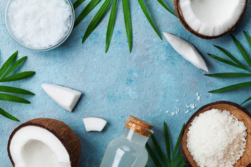 Blue background with set of organic coconut products for spa treatment, cosmetic or food ingredients. Oil, water and shavings top view. Flat lay. - obrazy, fototapety, plakaty