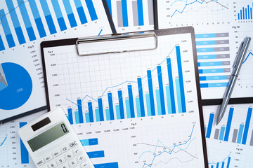Financial reports. Analyzing and gathering statistical data. Many blue growth charts, calculator...
