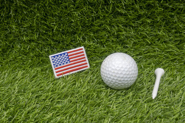 Golf ball with American flag is on green grass