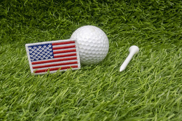Golf ball with American flag is on green grass