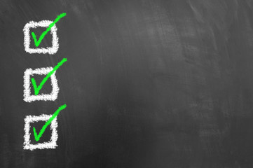 Three marked checkboxes drawing on chalkboard or blackboard.