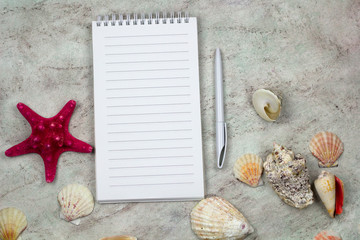 top view notebook with empty sheet, pen and sea shells