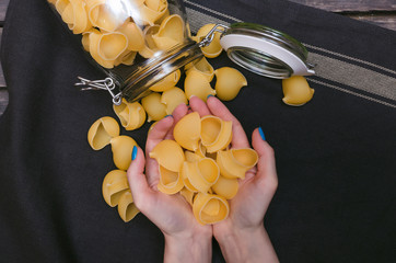 Different kinds of pasta in female hands.