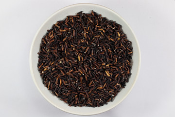 black rice whole grains in bowl isolated