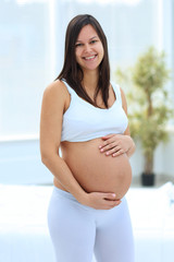 portrait of young pregnant woman on a light background.