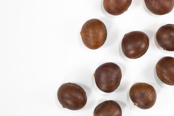 Chestnut , roasted beans brown color on white background .