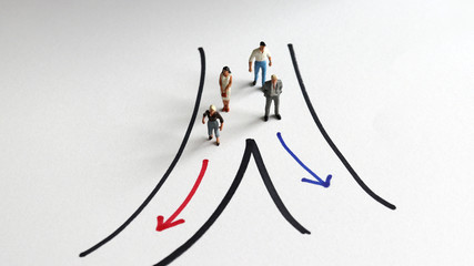 The concept of gender segregation. Two miniature men and two miniature women walking down the road...